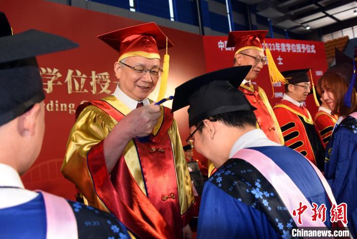 中科院院长侯建国院士为获得国科大学位学生代表扶正流苏。 中新社记者 孙自法 摄 中科院院长侯建国院士为获得国科大学位学生代表扶正流苏。 中新社记者 孙自法 摄
